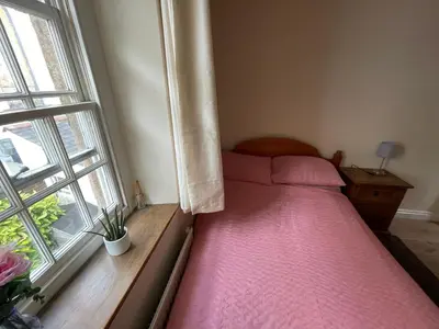 a small bedroom with a bed and a window at Robinsons Cottage, central and quiet in Cockermouth