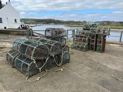 a pile of nets sitting next to a body of water at The Blue Door in Kirkcudbright