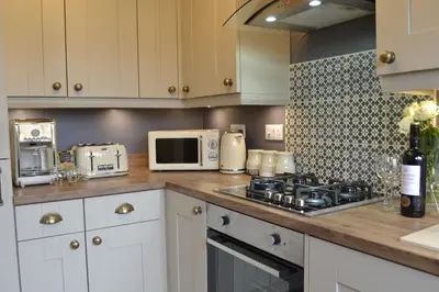 a kitchen with a stove and a microwave at Stunning Period Townhouse with Garden, Walking Distance to Town in Dumfries