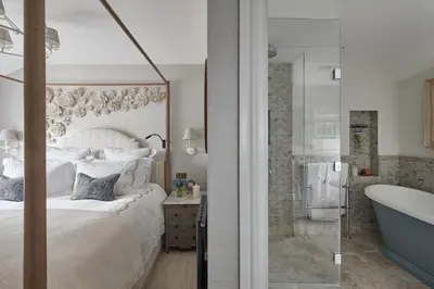 a bedroom with a large bed and a bath tub at Little Nut Cottage in Ambleside