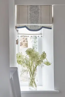 a vase with a plant sitting in a window at Little Nut Cottage in Ambleside