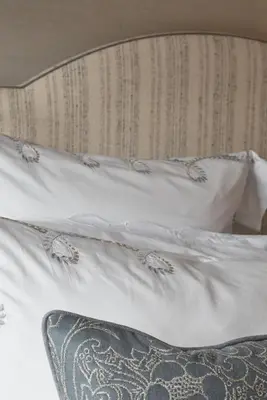 a bed with white sheets and pillows at Little Nut Cottage in Ambleside