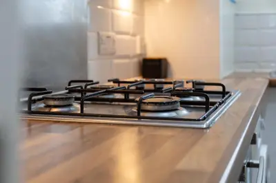 a stove top with four burners on a kitchen counter at Main Street View - Donnini Apartments in Prestwick
