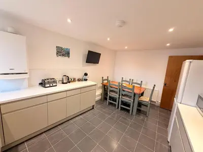 a kitchen and dining room with a table and a refrigerator at Low Haven in Keswick