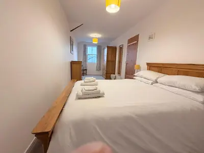 a bedroom with a large white bed with towels on it at Low Haven in Keswick
