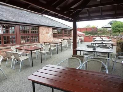 a group of tables and chairs in a patio at The Mill Forge Hotel in Gretna Green