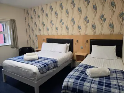 a bedroom with two beds with towels on them at The Mill Forge Hotel in Gretna Green