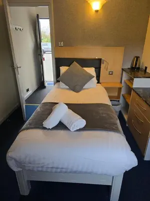 a hotel room with a large bed with two pillows at The Mill Forge Hotel in Gretna Green