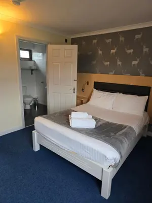 a bedroom with a large bed with towels on it at The Mill Forge Hotel in Gretna Green