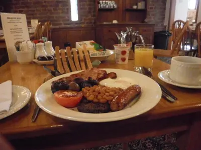 a plate of breakfast food on a wooden table at The Mill Forge Hotel in Gretna Green