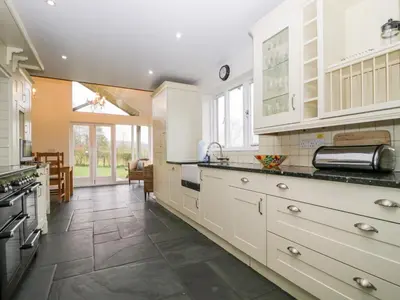 a kitchen with white cabinets and a tile floor at Beckwood in Penrith