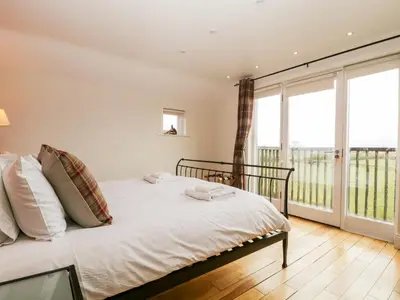 a bedroom with a bed and a large window at Beckwood in Penrith
