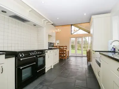 a kitchen with white cabinets and black appliances at Beckwood in Penrith