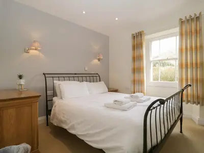 a bedroom with a bed with two towels on it at Glen Cottage in Penrith