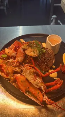 a plate of food with seafood and sauce on a table at Laundry Cottage in Lanark