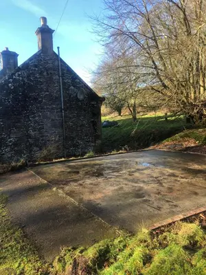 a stone house with a driveway in front of it at The Maid's House in Lanark