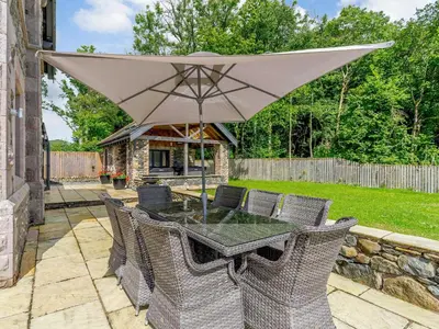 a patio with a table with an umbrella at Herdwick View - Uk33668 in Bassenthwaite Lake