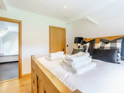 a bedroom with a bed with white sheets and a mirror at Herdwick View - Uk33668 in Bassenthwaite Lake