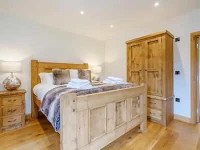 a bedroom with a large bed and a wooden cabinet at Herdwick View - Uk33668 in Bassenthwaite Lake