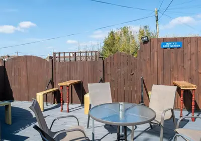 a patio with a table and chairs and a fence at Apartment 16 in Castle Douglas