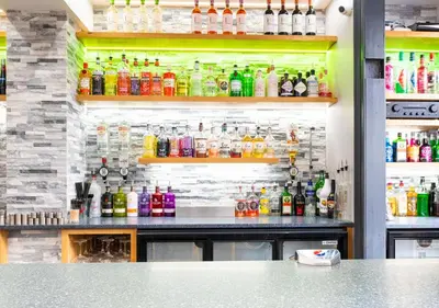 a bar with a lot of bottles of drinks at Apartment 16 in Castle Douglas