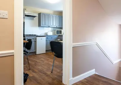 a kitchen with two chairs and a table in a room at Apartment 16 in Castle Douglas