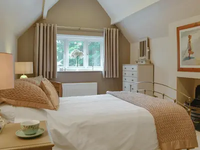 a bedroom with a large white bed and a window at The Coach House in Keswick