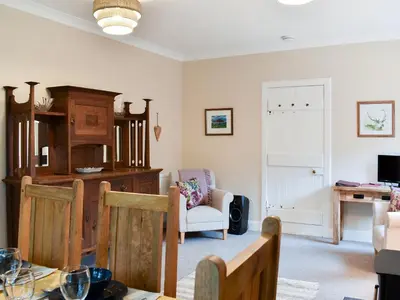 a living room with a table and a chair at Ingleside in Whiting Bay