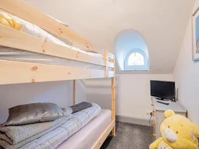 a bedroom with two bunk beds and a television at Harbour View House in Girvan