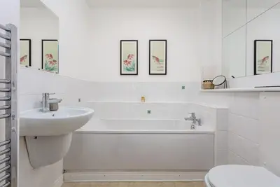 a white bathroom with a sink and a tub and a toilet at Walker Suite No54 - Donnini Apartments in Kilmarnock