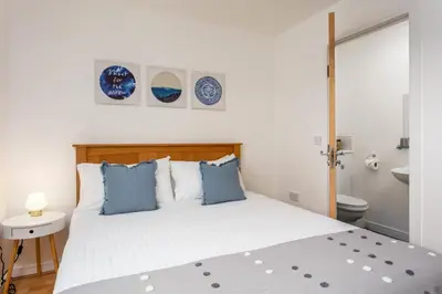 a bedroom with a white bed with blue pillows at Walker Suite No54 - Donnini Apartments in Kilmarnock