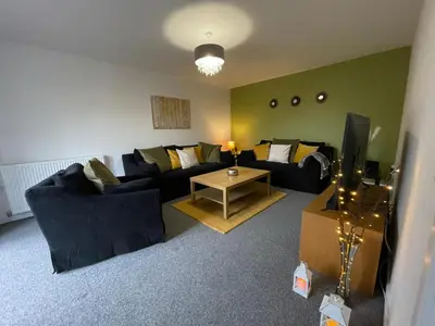 a living room with two couches and a tv at The Old Stables 17a in Dumfries
