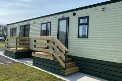 a green trailer with a wooden staircase on it at Caravan - Sleeps 4 - Pet friendly - Parking in Newton Stewart