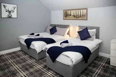 a bedroom with two beds with towels on them at St Andrews Guest House in Irvine