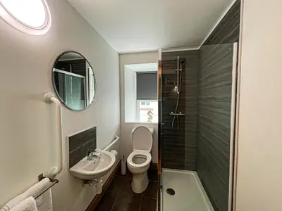 a bathroom with a toilet and a sink and a mirror at Harbourside Apartments in Portpatrick
