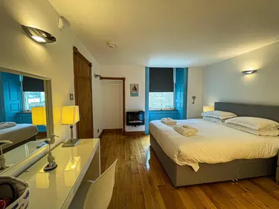 a bedroom with a large bed and a bathroom at Harbourside Apartments in Portpatrick