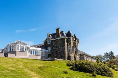 an old house on a grassy hill at Fernhill Hotel in Portpatrick