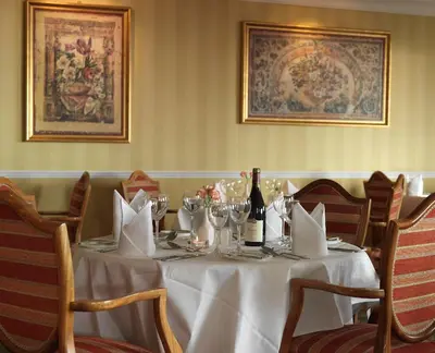 a table with a white table cloth and a bottle of wine at Fernhill Hotel in Portpatrick