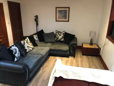 a living room with a couch and a table at Ochiltree cottage in Newton Stewart