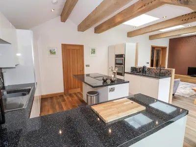 a kitchen with black counter tops and a kitchen island at The Nook in Keswick