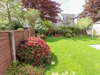 a yard with a fence and flowers at The Nook in Keswick
