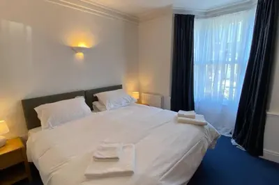 a bedroom with a large white bed with towels on it at Poet's Corner - flat close to centre of Keswick in Keswick