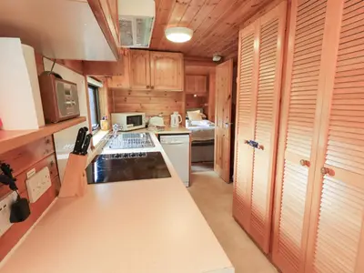 a kitchen with wooden cabinets and a stove top oven at Squirrels Leap in Keswick