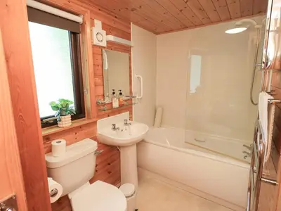 a bathroom with a toilet and a sink and a tub at Squirrels Leap in Keswick