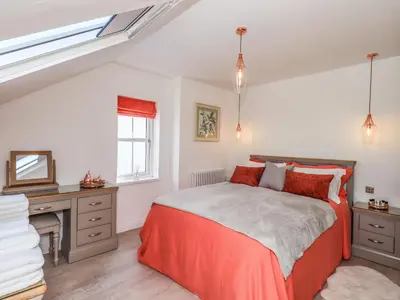 a bedroom with a bed and a desk and a window at Seascape in Annan