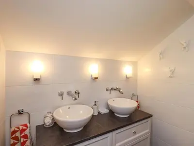 a bathroom with two sinks and two lights on the wall at Seascape in Annan