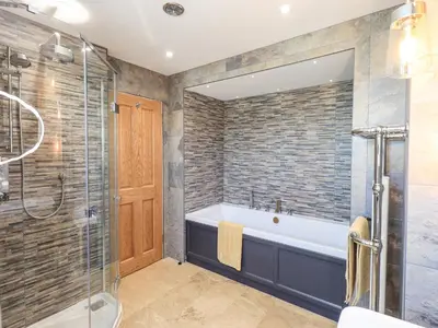 a bathroom with a tub and a glass shower at Seascape in Annan