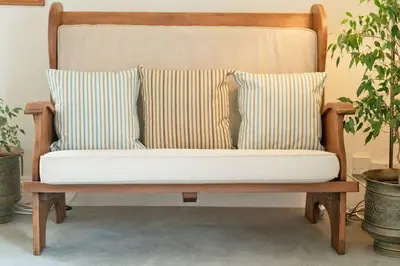a wooden bench with two pillows on it at Troon Arts & Crafts Period Home Golf Beach in Troon