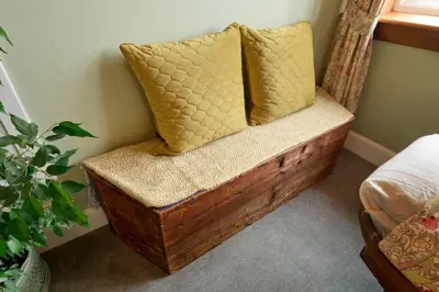 a bench with two pillows on it in a bedroom at Troon Arts & Crafts Period Home Golf Beach in Troon