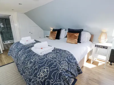 a bedroom with a bed with a blue and white blanket at Ailsa Shores in Turnberry
